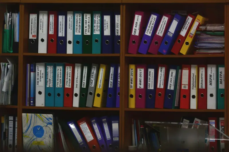 Stacks of documents and file folders on a desk